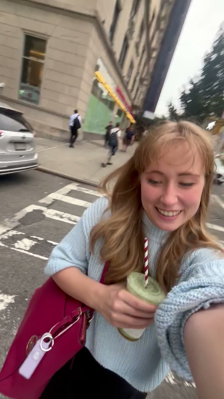 Woman smiling on a city street with Sally on her bag